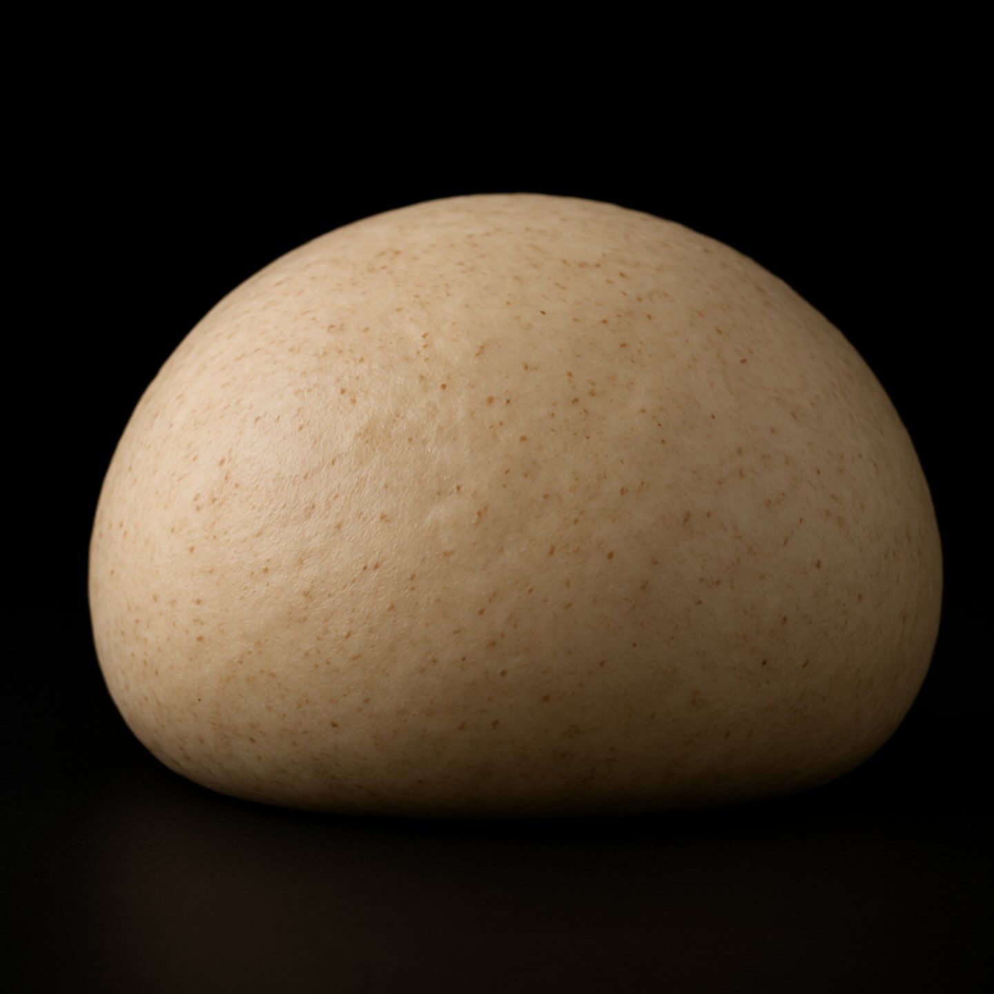 Una palla di pasta è appoggiata su una superficie nera