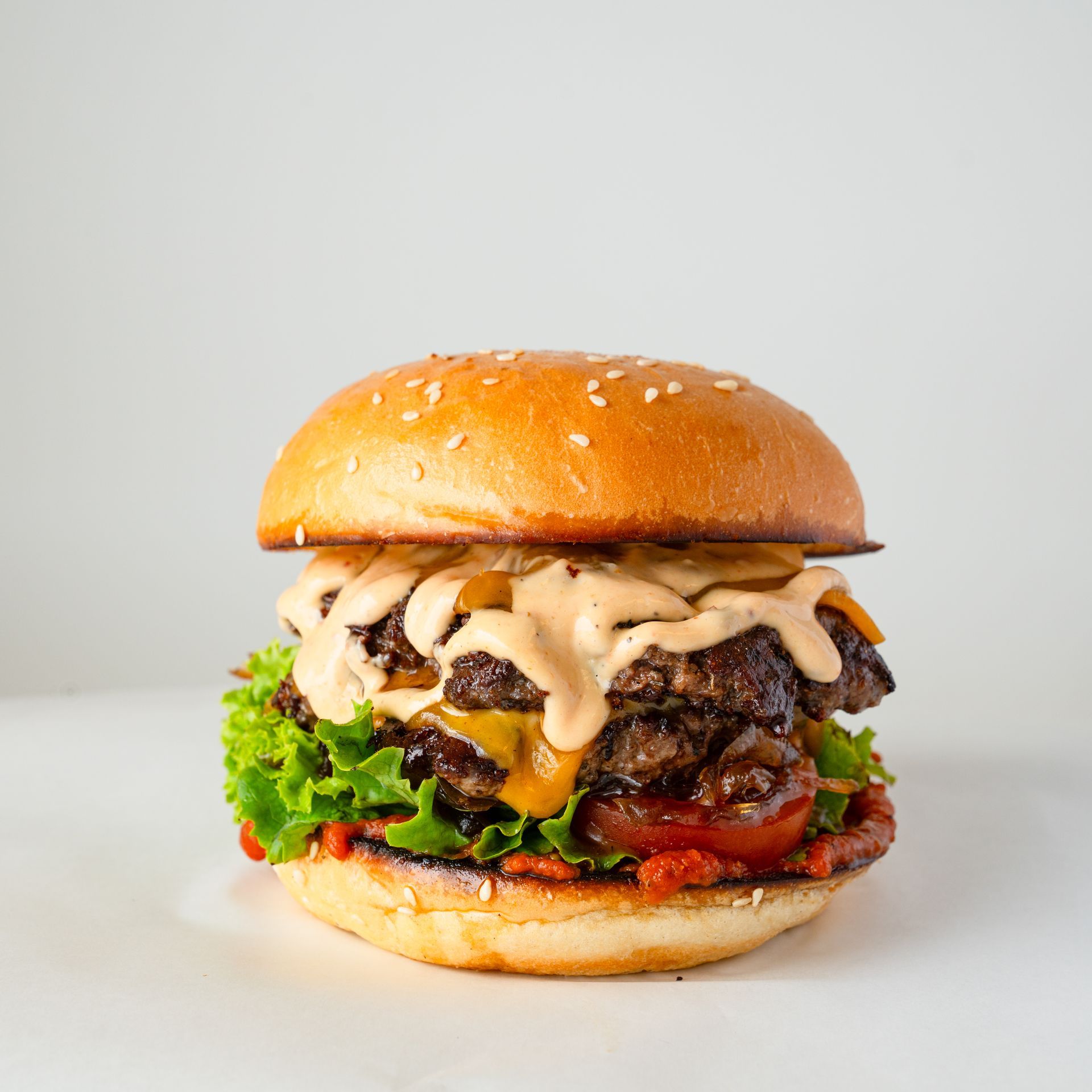 Un primo piano di un hamburger su un panino su un tavolo.