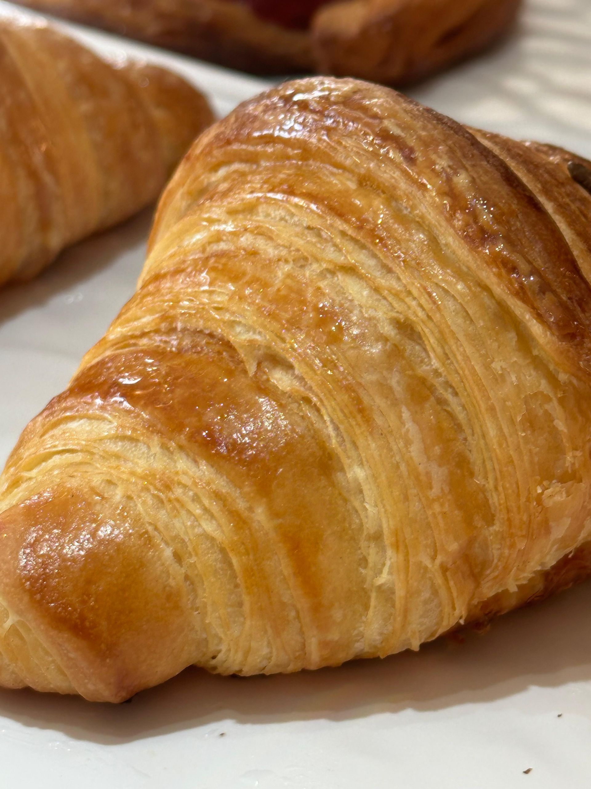 Primo piano di un croissant su un piatto bianco.