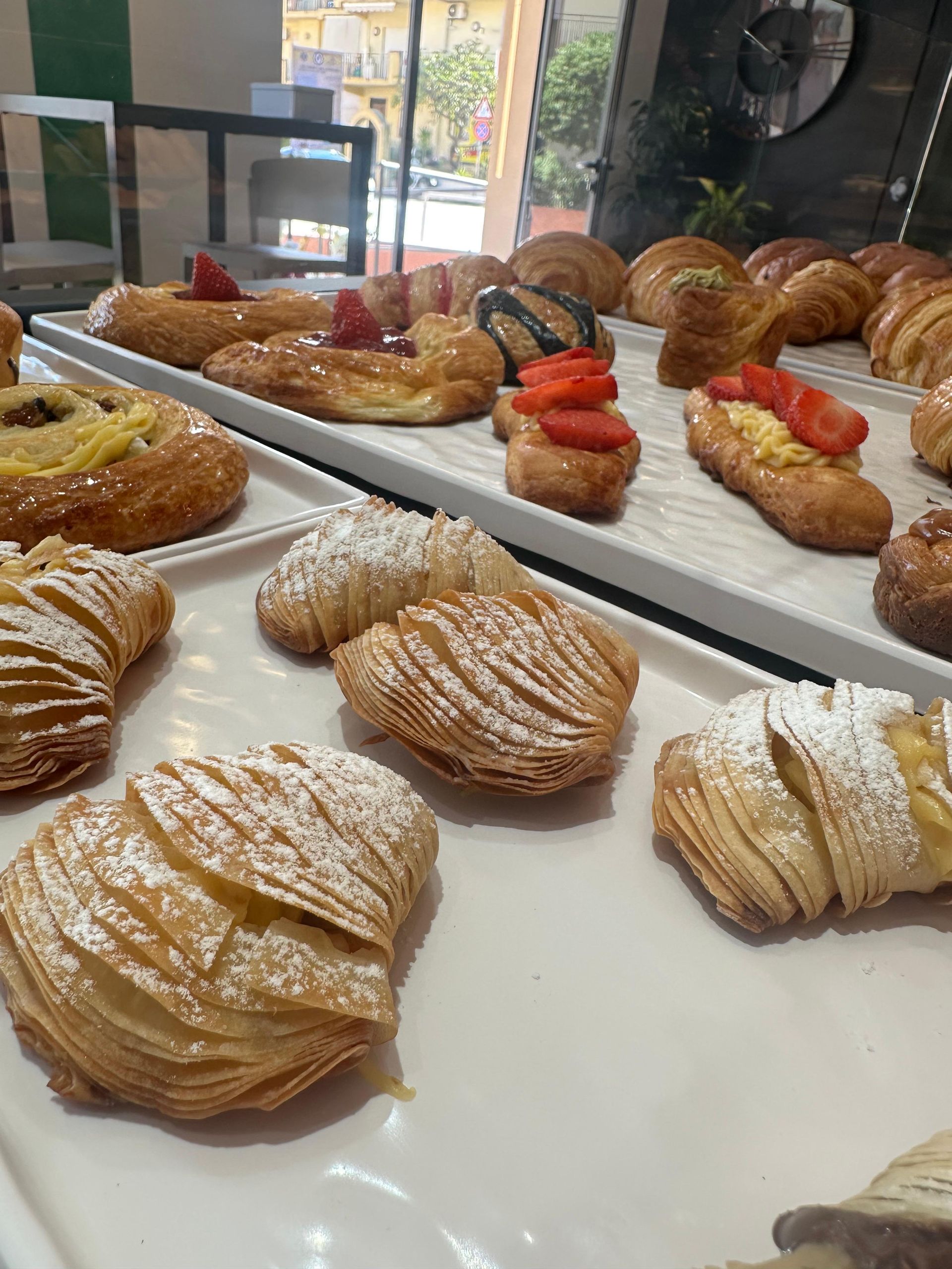 In una panetteria, su un vassoio sono disposti vari tipi di pasticcini.