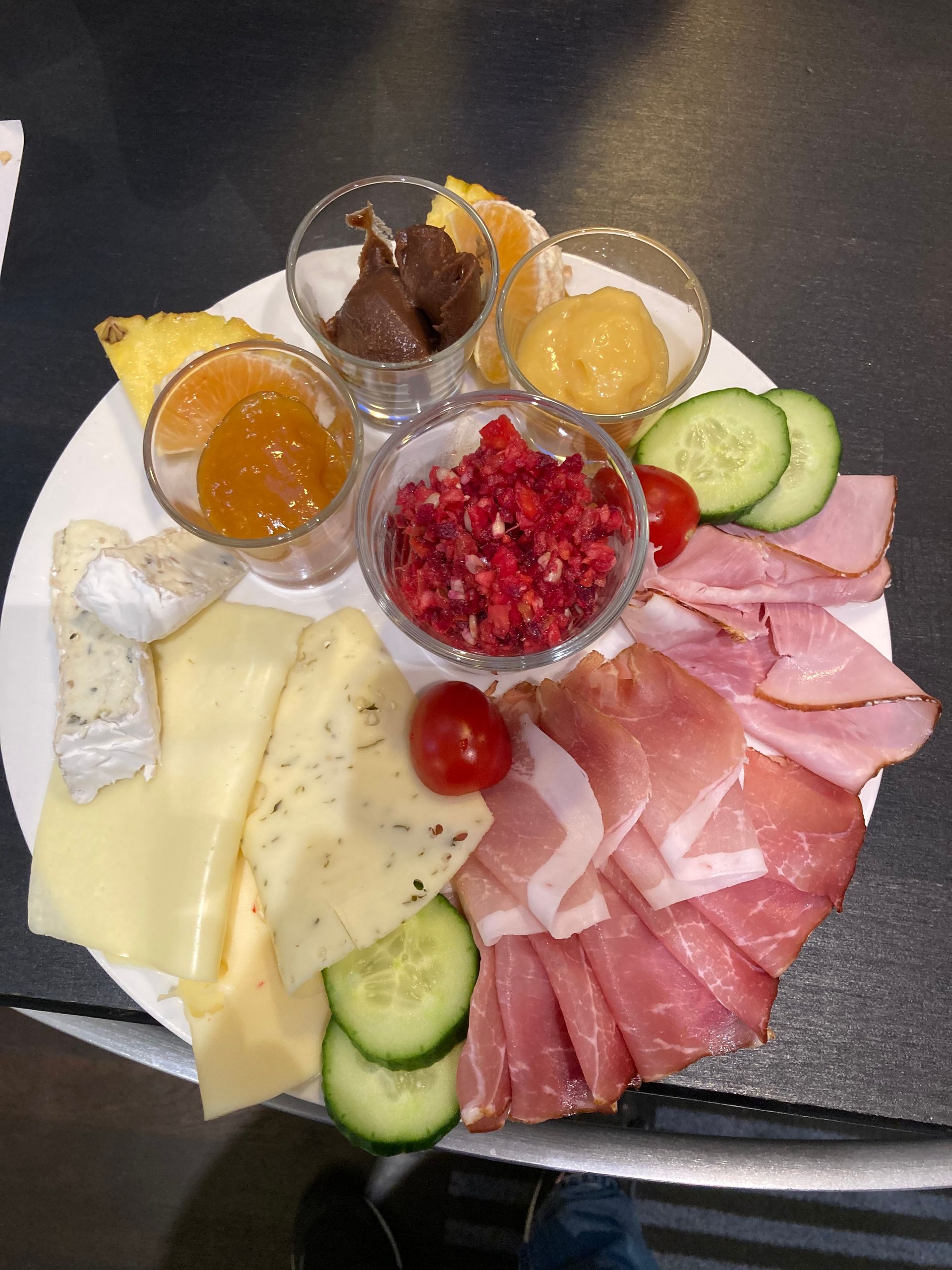 Ein Teller mit Essen mit Schinken, Käse und Gemüse auf einem Tisch