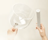 Eine Person hält eine durchsichtige Schüssel und einen weißen Stock.