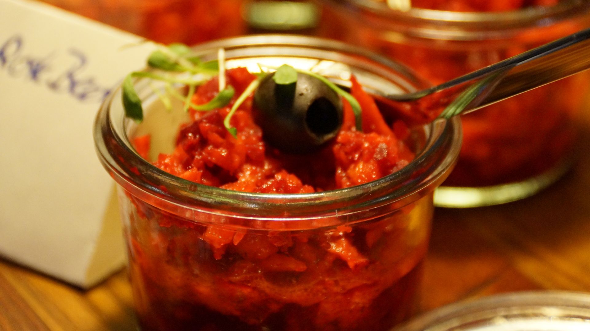 Eine Nahaufnahme eines Glases mit Essen und einem Löffel darin.