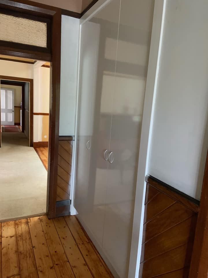 Hallway With Wooden Floors and a White Door — Hancock Construction & Maintenance in Newcastle, NSW