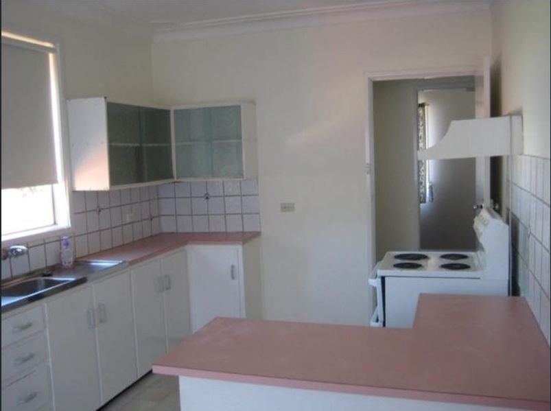 Kitchen With White Cabinets and a White Stove — Hancock Construction & Maintenance in Newcastle, NSW