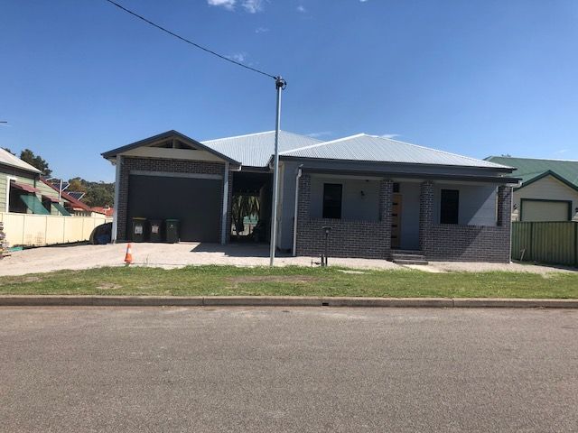 House With a Garage and a Fence in Front of It — Hancock Construction & Maintenance in Port Stephens, NSW