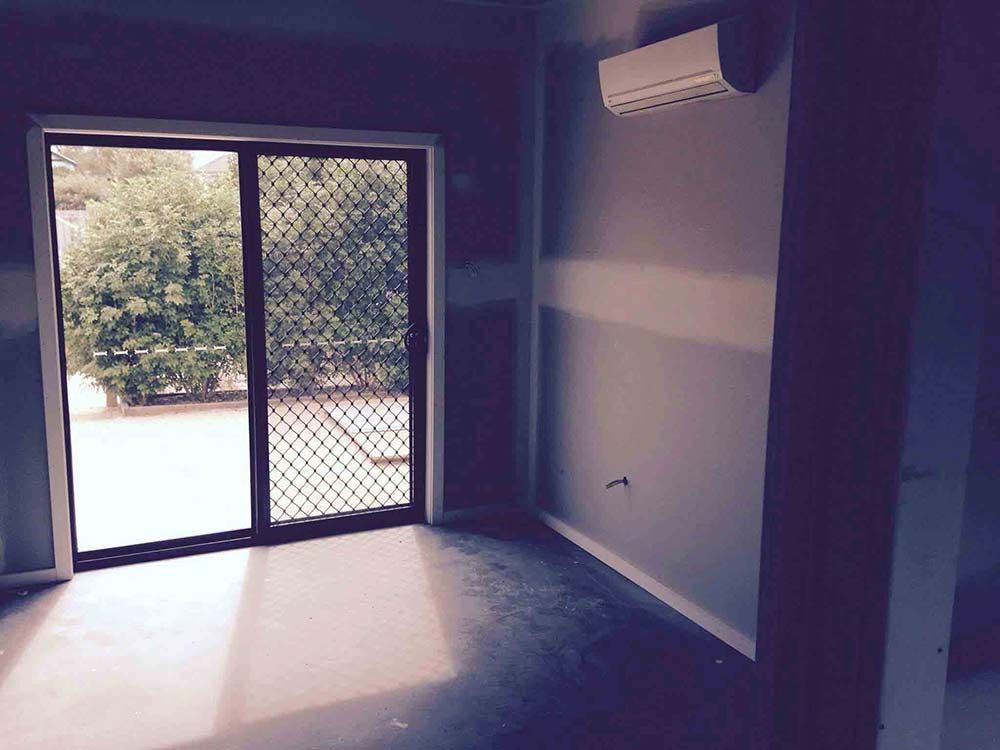 Empty Room With a Sliding Glass Door and a Window — Hancock Construction & Maintenance in Cessnock, NSW