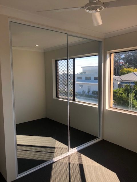 Bedroom With Sliding Glass Doors and a Ceiling Fan — Hancock Construction & Maintenance in Cessnock, NSW
