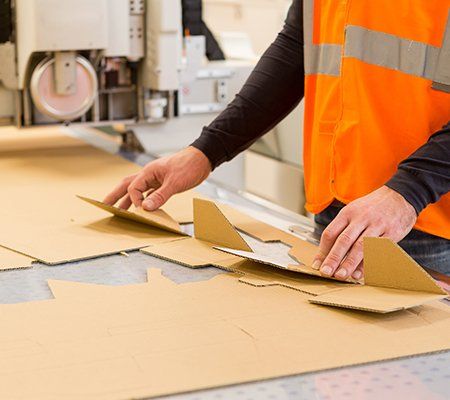 Box Manufacturer — Man Folding Cardboard at the Production Plant in Indianapolis, IN