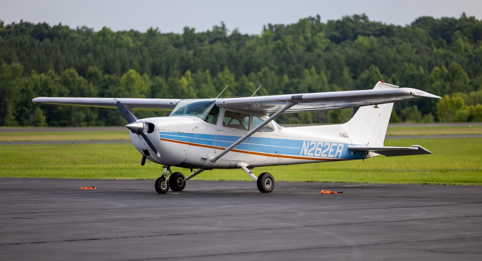 A small plane is parked on the runway at an airport.