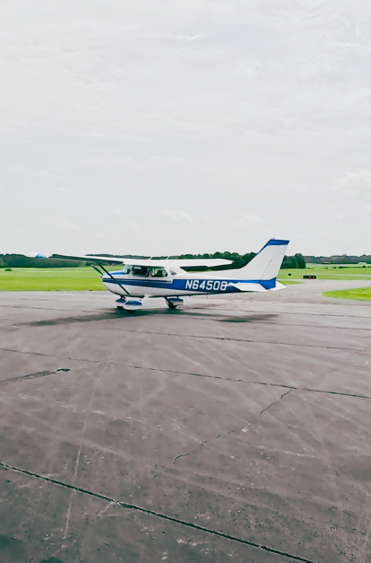 A small plane is parked on the runway of an airport.