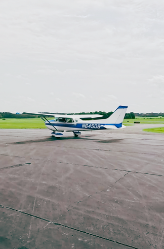 A small plane is parked on the runway of an airport.