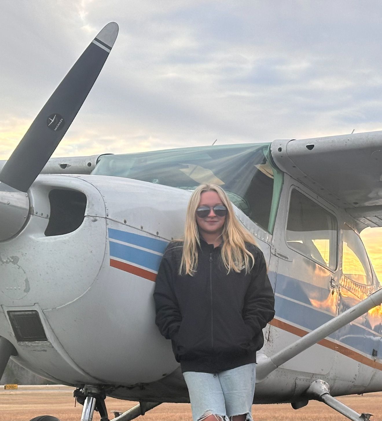 A yellow dice with a smiley face on it is sitting on the ground.
