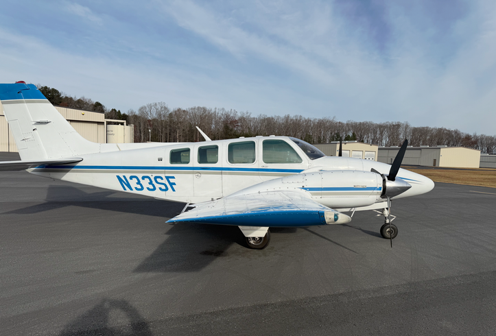 A small plane is parked on the runway of an airport.