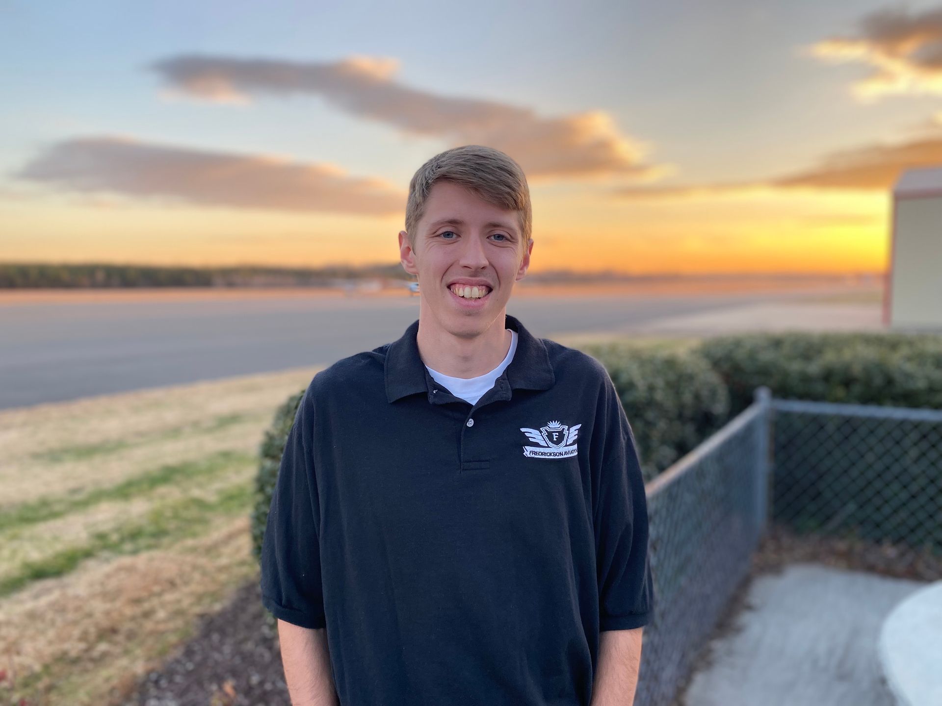 A yellow dice with a smiley face on it is sitting on the ground.