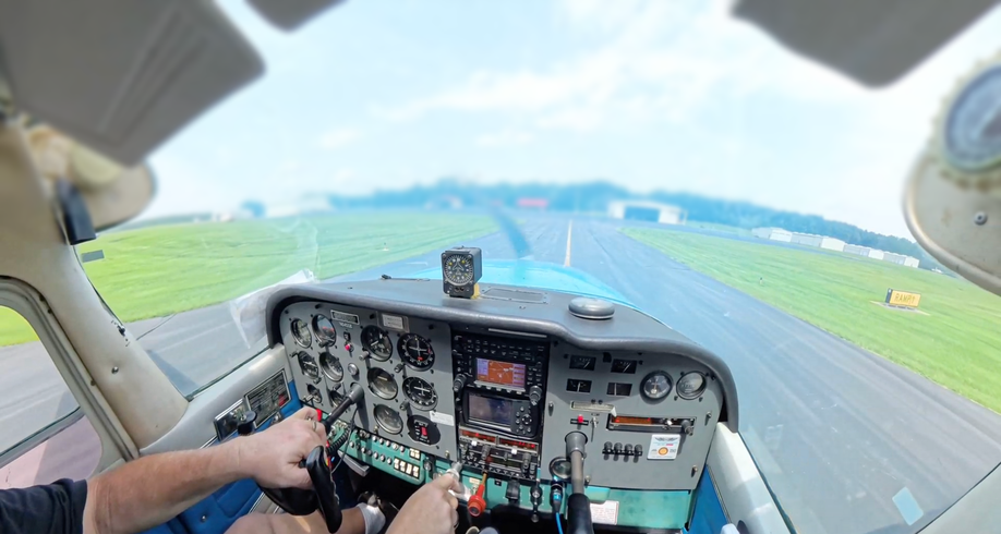 A man is flying a small plane on a runway.