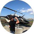 A man is standing in front of a helicopter.