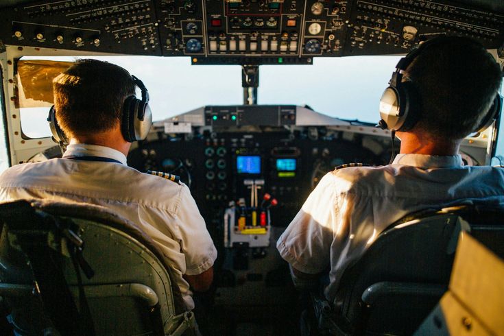 Two pilots are sitting in the cockpit of an airplane