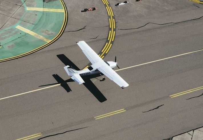 An aerial view of a small plane taking off from a runway