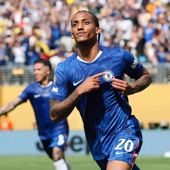 Um jogador de futebol com uma camisa listrada azul e branca está comemorando um gol.