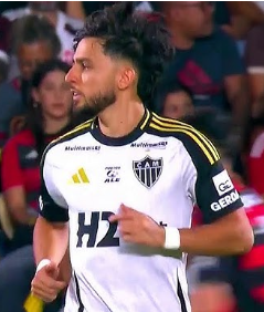 Um jogador de futebol vestindo uma camisa listrada de vermelho e azul com a letra s