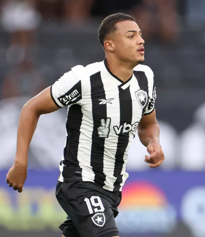 Um homem vestindo uma camisa de pari está em um campo