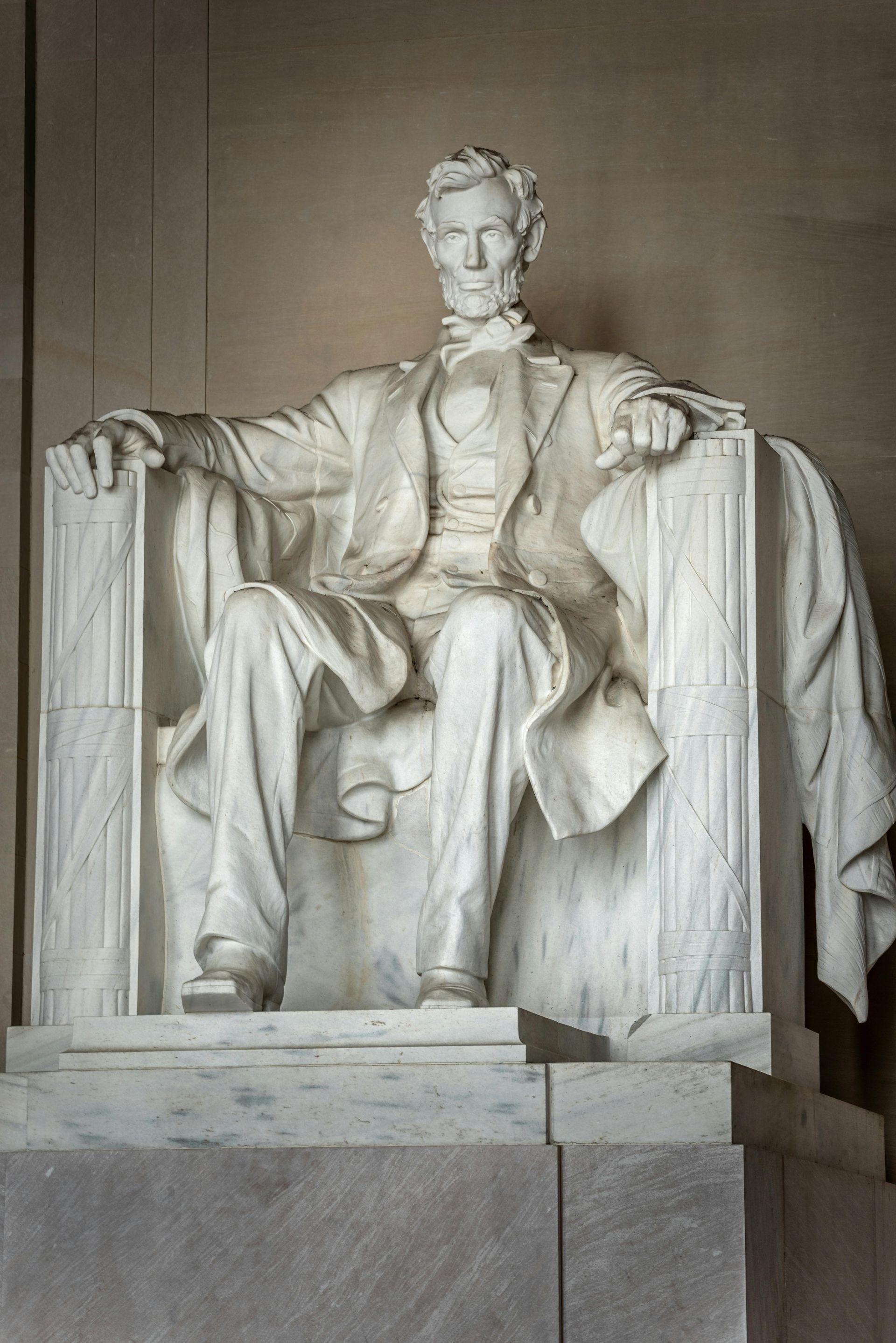 A statue of abraham lincoln is sitting in a chair.
