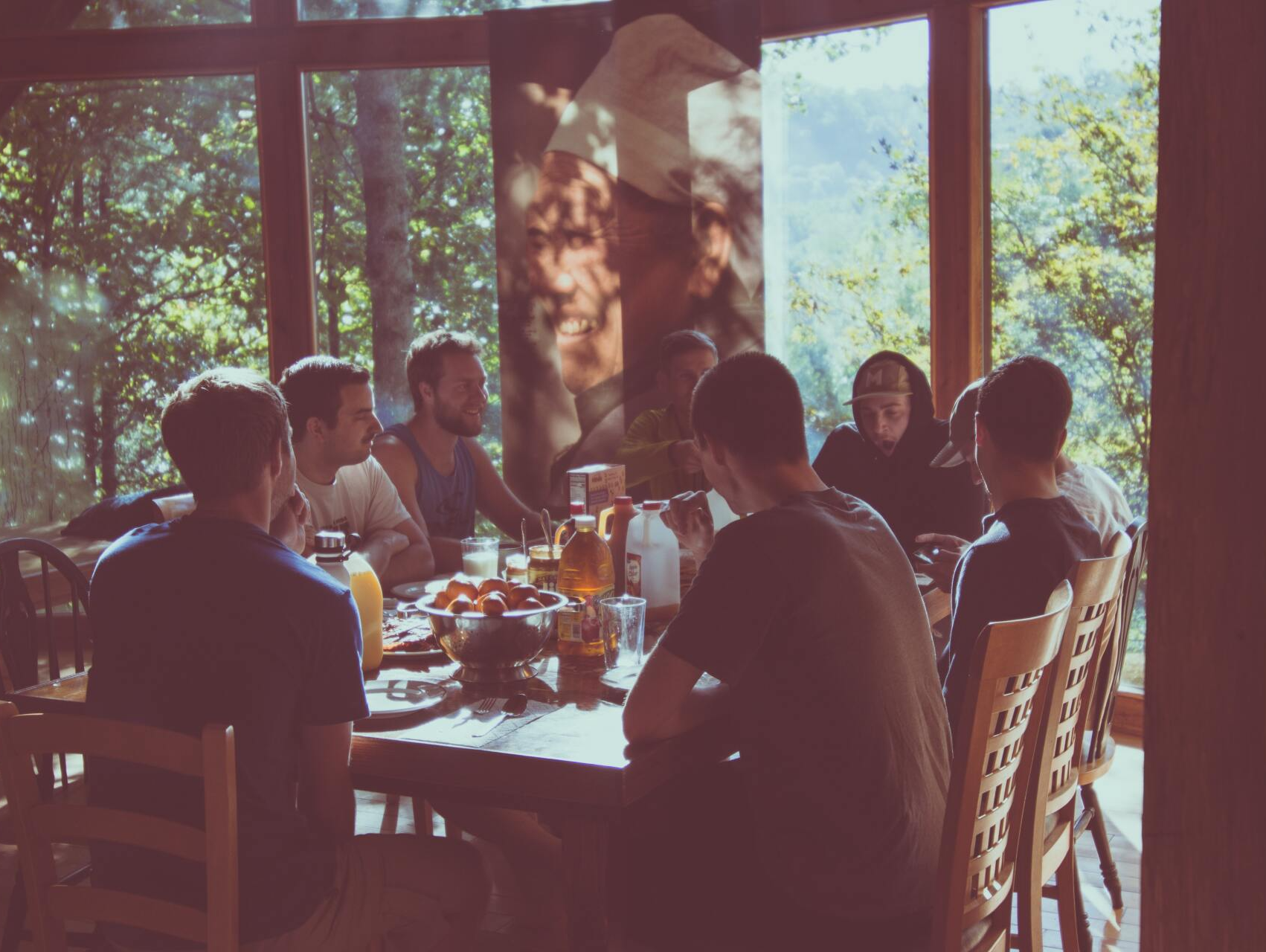 A group of people are sitting around a table eating food.