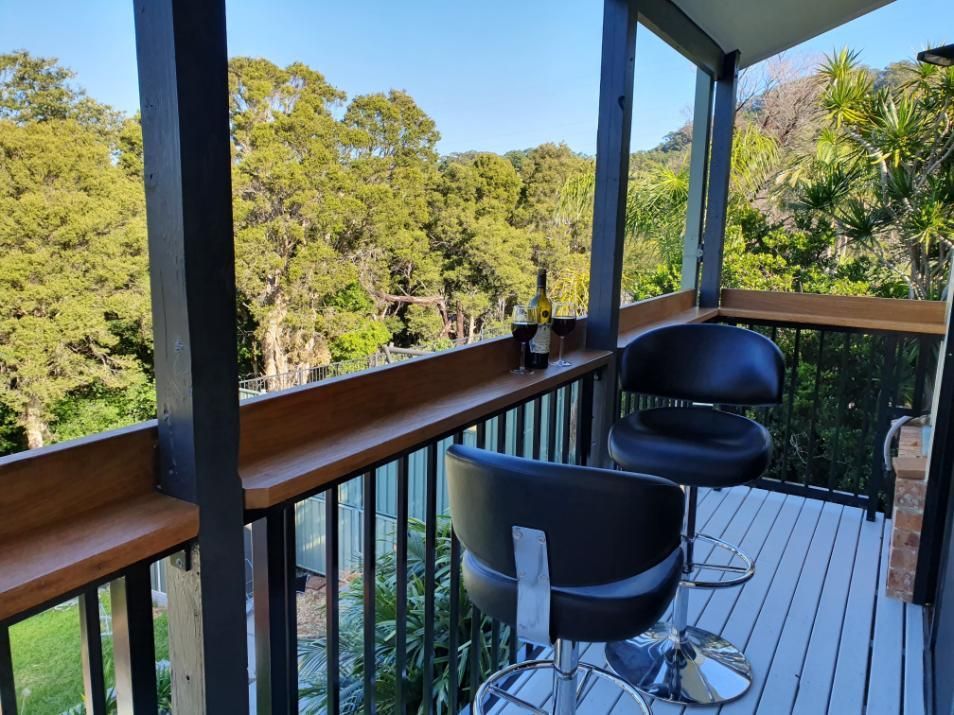 A Balcony With Two Chairs and a View of Trees — Lifestyle Aluminium Fabrication In Kiama, NSW