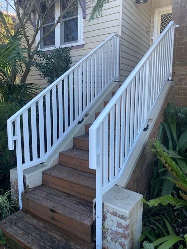 A White Railing With Wooden Steps Leading Up to a House — Lifestyle Aluminium Fabrication In Fairy Meadow, NSW