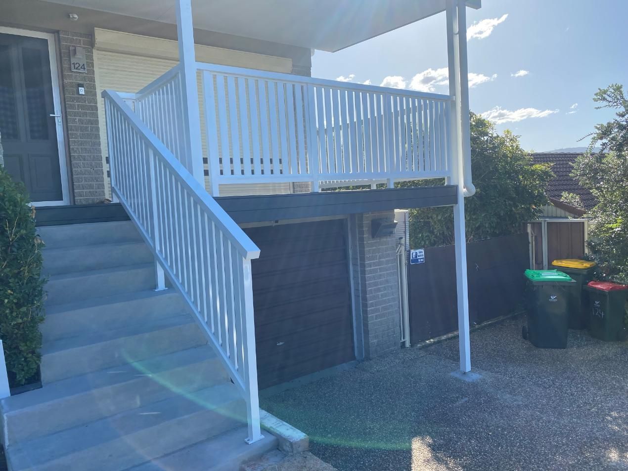 A White Railing on the Side of a House With Stairs Leading Up to It — Lifestyle Aluminium Fabrication In Wollongong, NSW