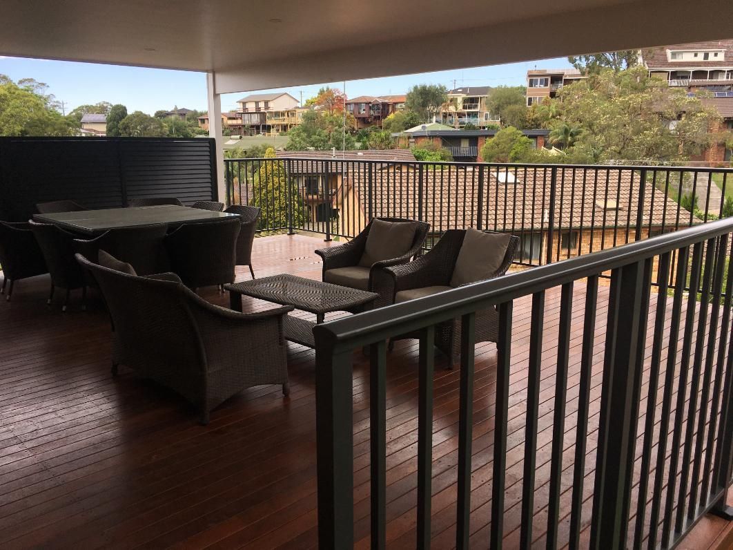 A Balcony With a Table and Chairs on It — Lifestyle Aluminium Fabrication In Wollongong, NSW