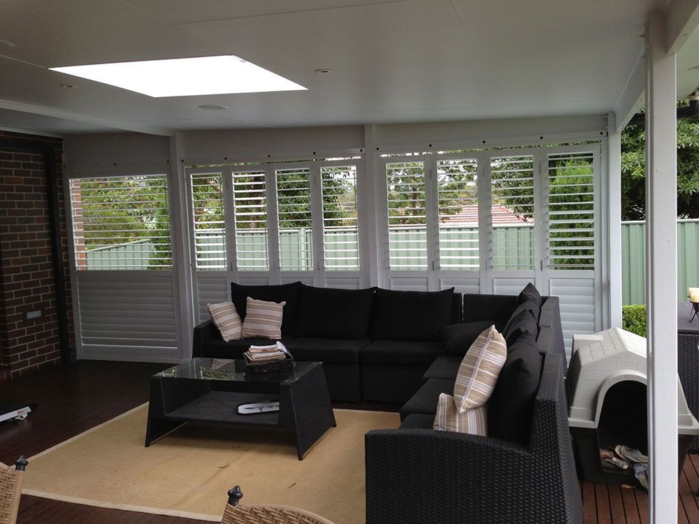 A Living Room With A Couch And A Coffee Table — Lifestyle Aluminium Fabrication In Albion Park Rail, NSW