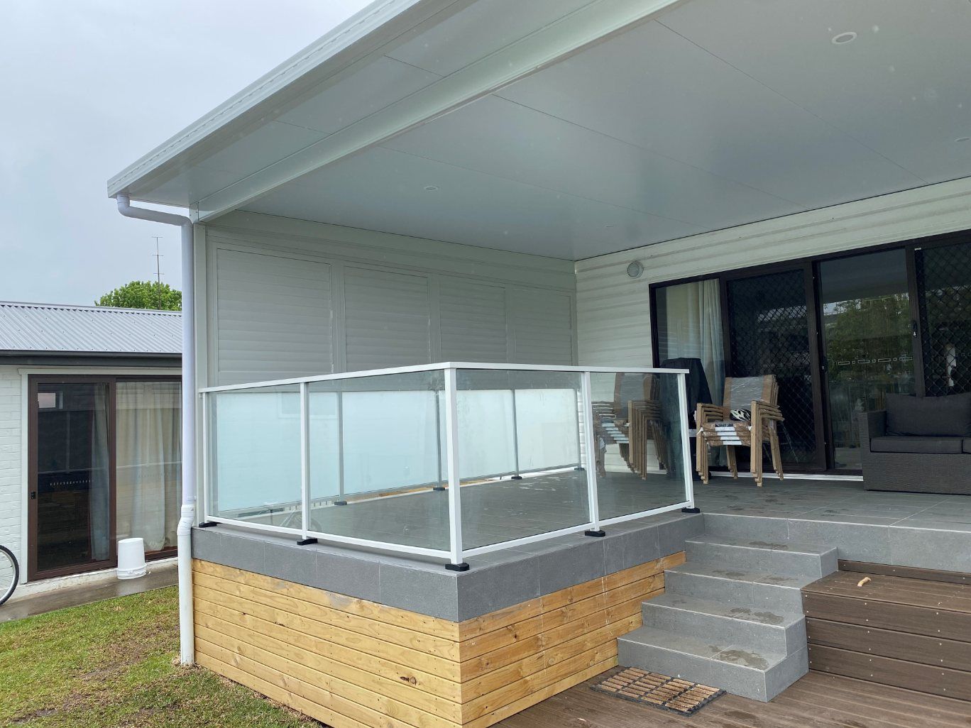 A Balcony with A White Railing and A Window with A View of A City — Lifestyle Aluminium Fabrication In Albion Park Rail, NSW