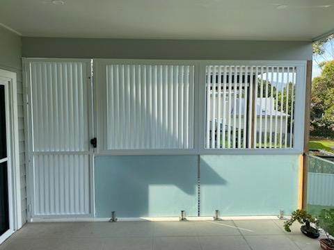 A Screened in Porch With Blinds and a Door — Lifestyle Aluminium Fabrication In Wollongong, NSW