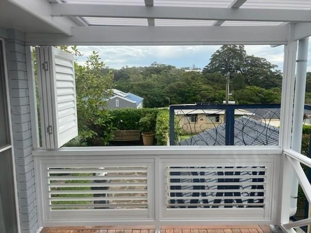 A Balcony With Shutters on It and a View of a House — Lifestyle Aluminium Fabrication In Kiama, NSW