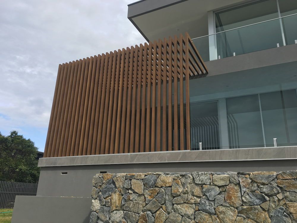 A Large House with A Large Balcony and A Stone Wall — Lifestyle Aluminium Fabrication In Kiama, NSW
