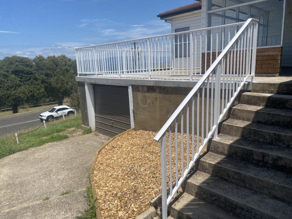 A White Railing Leading up To a Balcony on Top of A Set of Stairs — Lifestyle Aluminium Fabrication In Albion Park Rail, NSW