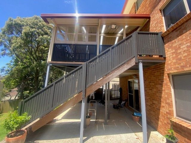 A staircase leading up to a balcony on the side of a brick building.