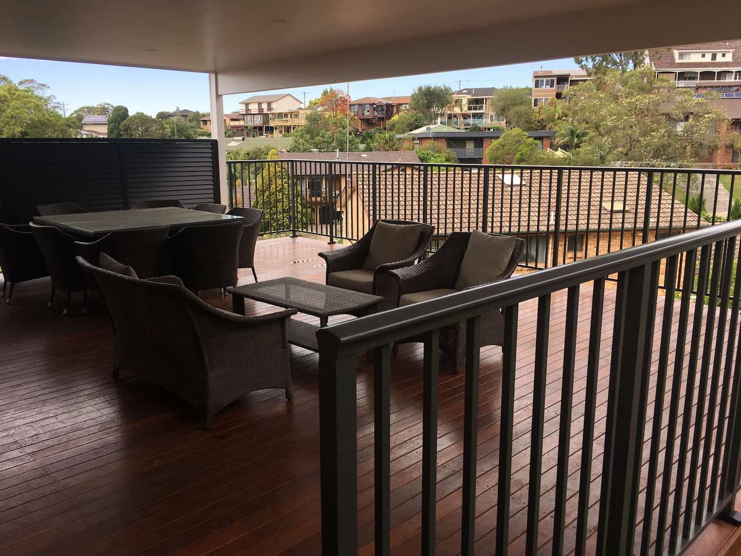 A Deck with A Table and Chairs on It — Lifestyle Aluminium Fabrication In Fairy Meadow, NSW
