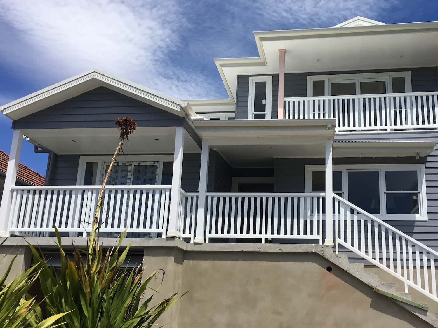 A Large House with A White Railing and Stairs Leading up To It — Lifestyle Aluminium Fabrication In Fairy Meadow, NSW