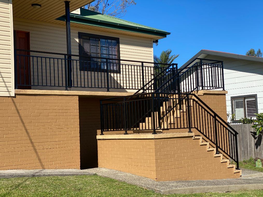 A House with A Balcony and Stairs on The Side of It — Lifestyle Aluminium Fabrication In Albion Park Rail, NSW