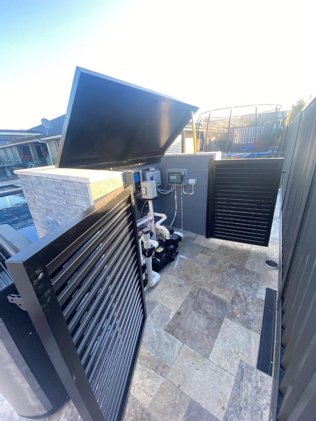 A Black Fence Is Surrounding a Patio with A Table and Chairs — Lifestyle Aluminium Fabrication In Albion Park Rail, NSW