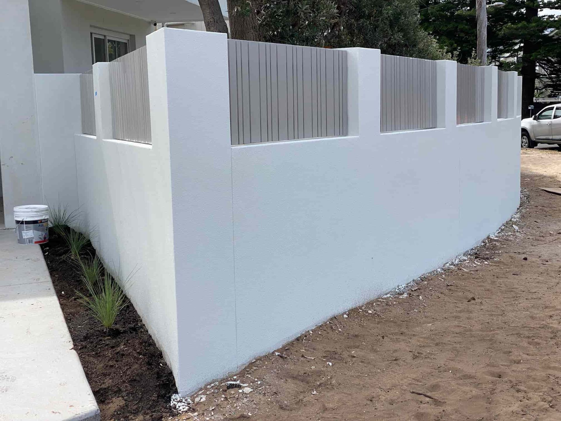 A White Fence Surrounds a Driveway in Front of A House — Lifestyle Aluminium Fabrication In Shellharbour, NSW
