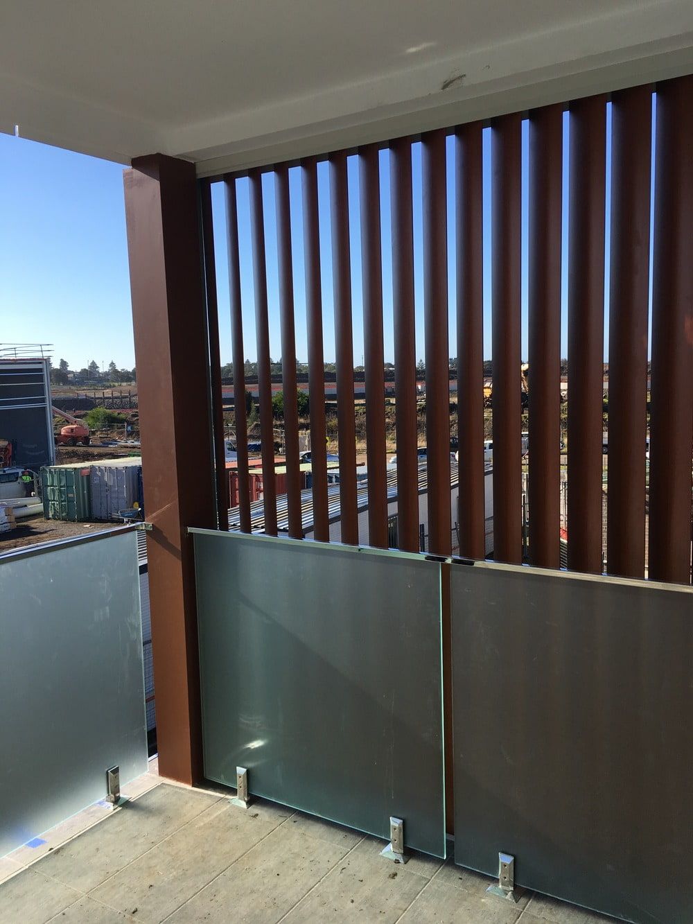 A Balcony With A Wooden Fence And A View Of A City — Lifestyle Aluminium Fabrication In Albion Park Rail, NSW