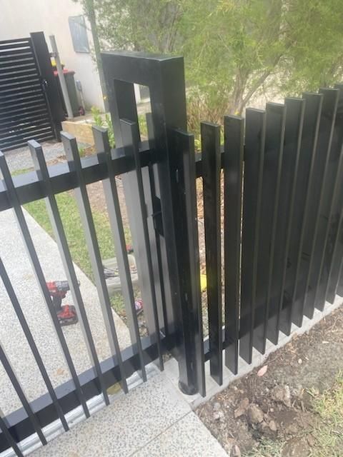 A Black Metal Fence With a Gate is Being Built — Lifestyle Aluminium Fabrication In Fairy Meadow, NSW