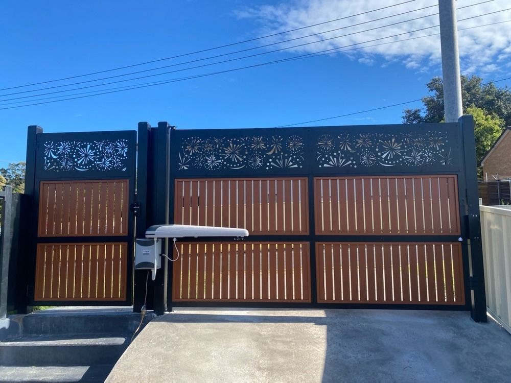 A Wooden Gate With A Black Frame And A Motor Is Open — Lifestyle Aluminium Fabrication In Wollongong, NSW