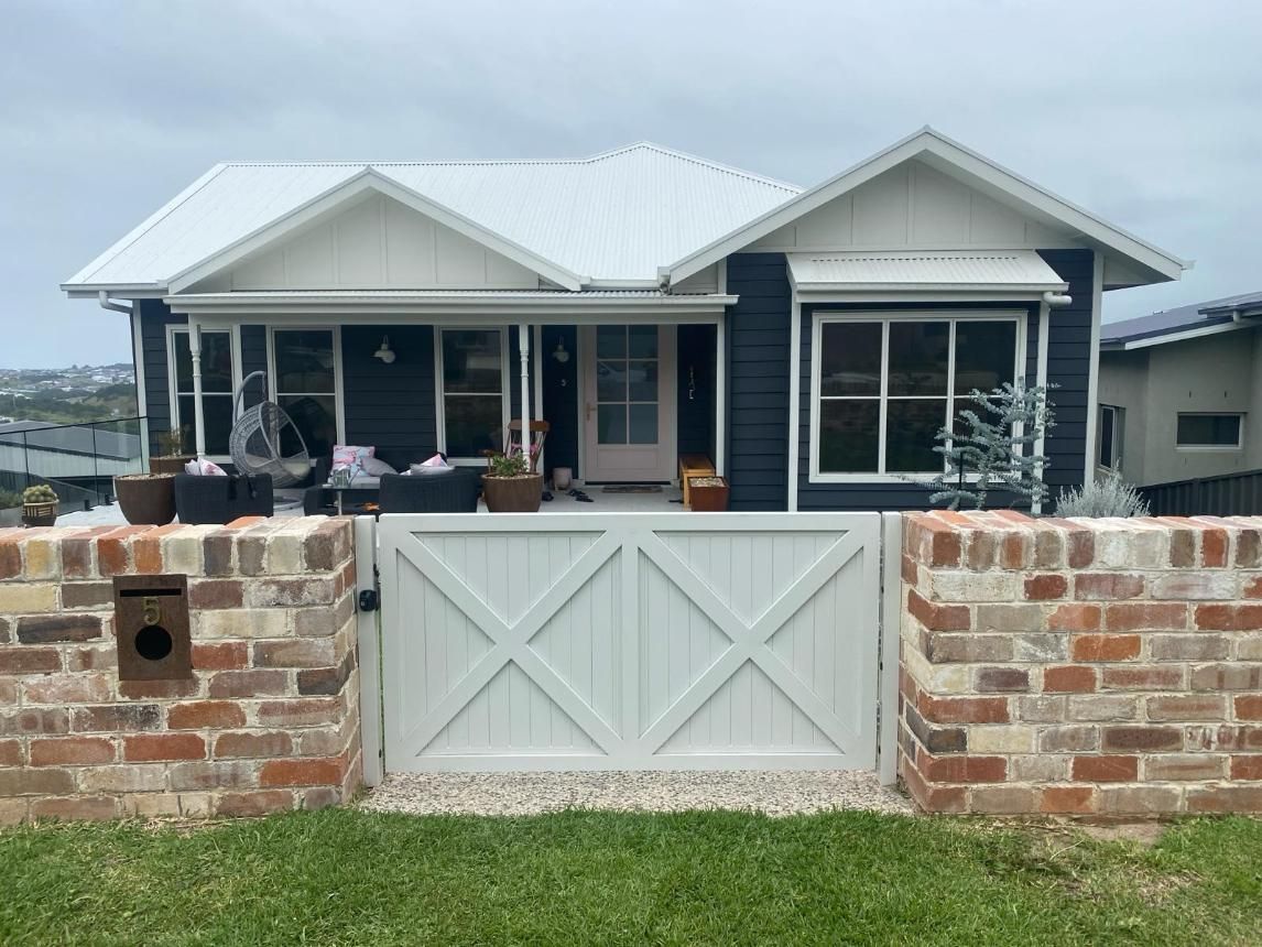 A House With a Brick Wall and a White Gate in Front of It — Lifestyle Aluminium Fabrication In Kiama, NSW
