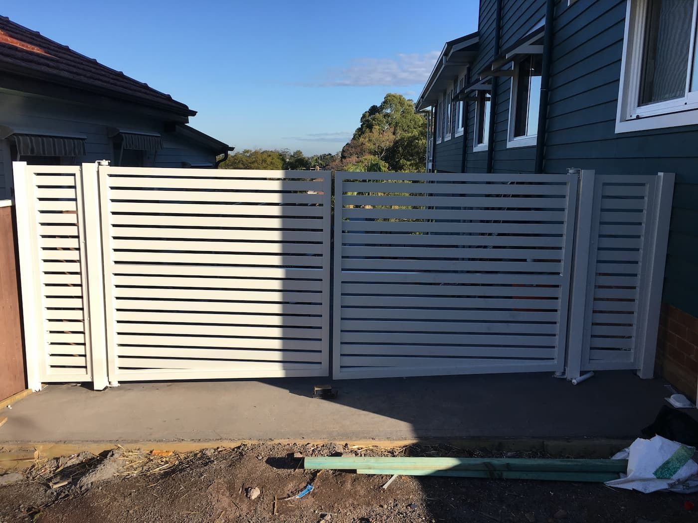 A White Fence Is Sitting in Front of A House — Lifestyle Aluminium Fabrication In Kiama, NSW