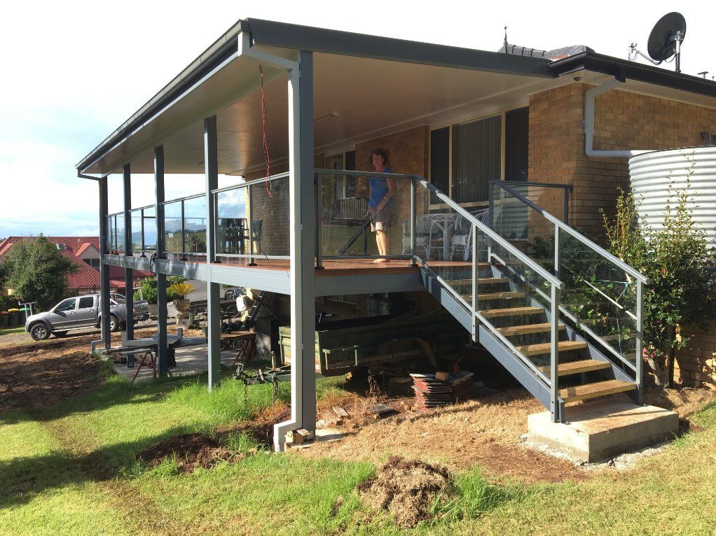 A Large Swimming Pool with A Glass Fence Around It — Lifestyle Aluminium Fabrication In Albion Park Rail, NSW